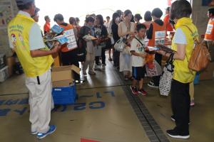 入場口でクリアファイルをプレゼントしている